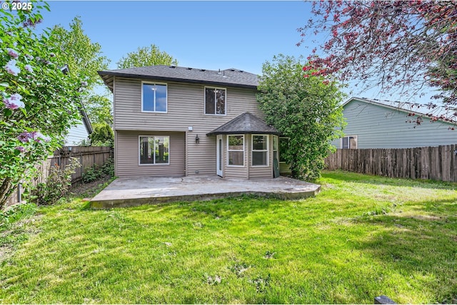 rear view of house featuring a fenced backyard, a patio, and a yard