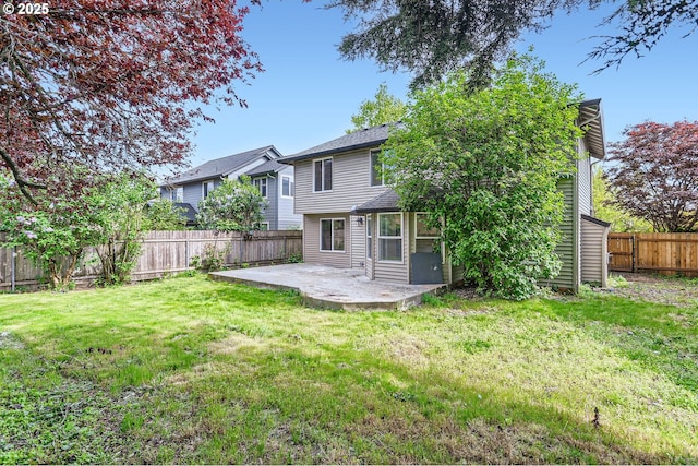 rear view of property with a fenced backyard, a patio area, and a yard