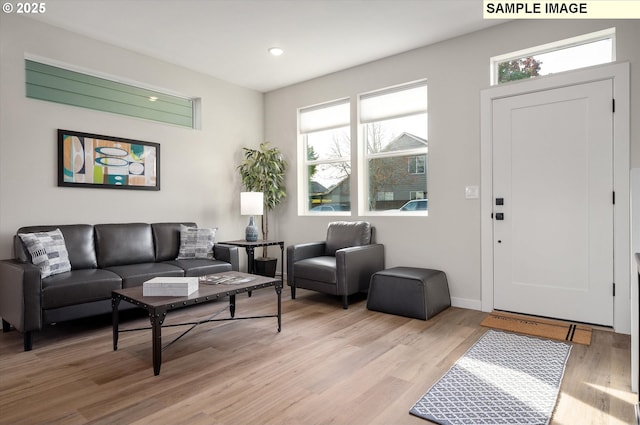 living room with light wood finished floors, baseboards, and recessed lighting