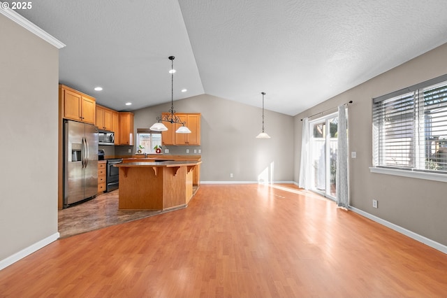 kitchen with pendant lighting, stainless steel appliances, a kitchen breakfast bar, a kitchen island, and vaulted ceiling