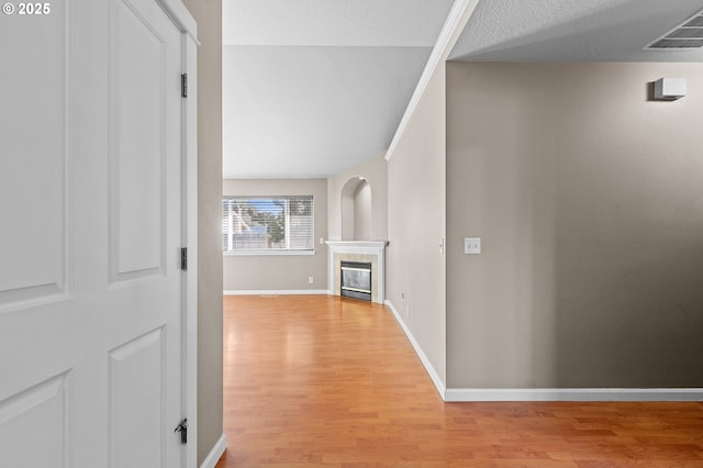 hall with a textured ceiling and light hardwood / wood-style flooring