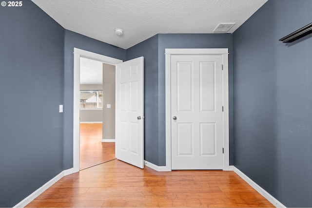 unfurnished bedroom featuring light hardwood / wood-style floors and a textured ceiling