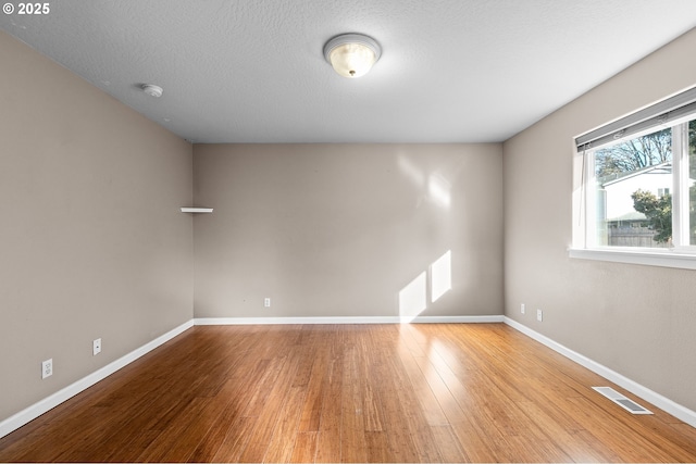 empty room featuring light hardwood / wood-style floors and a textured ceiling