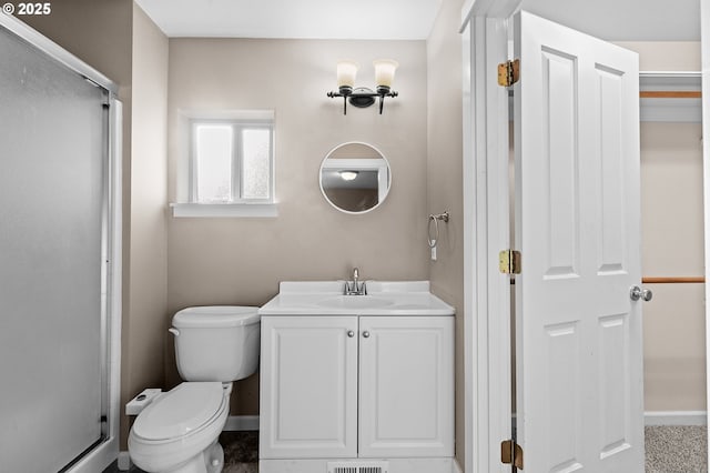 bathroom featuring vanity, toilet, and walk in shower