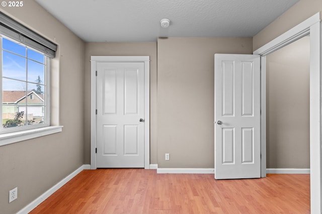 unfurnished bedroom featuring a textured ceiling and light hardwood / wood-style floors