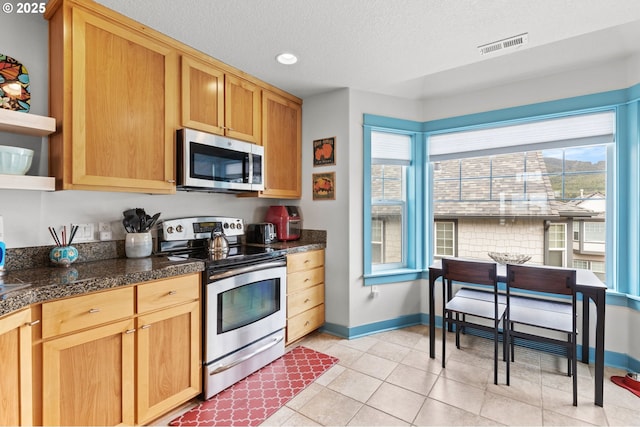 260 N Pacific St, Rockaway Beach, OR 97136 - kitchen featuring appliances with stainless steel finishes, tile counters, a textured ceiling, baseboards, and recessed lighting