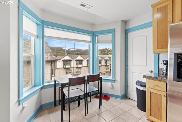 260 N Pacific St, Rockaway Beach, OR 97136 - dining area featuring baseboards, light tile patterned flooring, and a textured ceiling