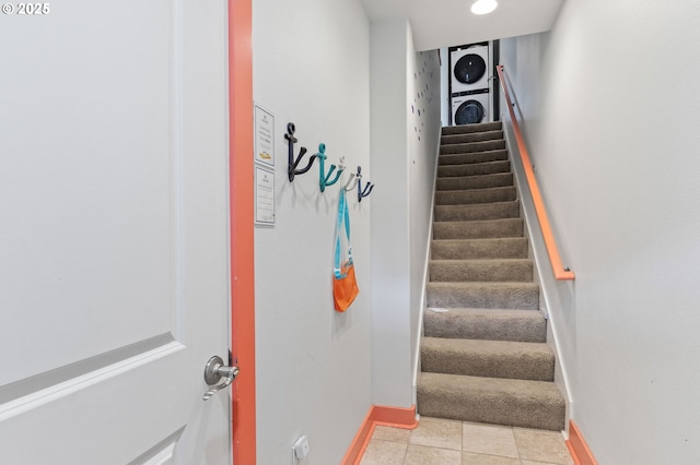 260 N Pacific St, Rockaway Beach, OR 97136 - stairway with stacked washer / dryer, baseboards, and tile patterned floors