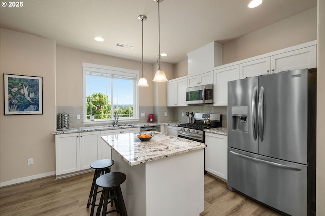 28683 SW Orleans Ave, Wilsonville, OR 97070 - kitchen with appliances with stainless steel finishes, light wood-style floors, backsplash, a sink, and recessed lighting