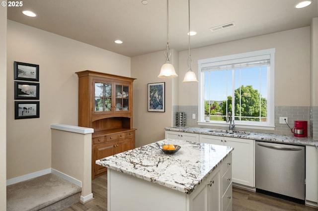 28683 SW Orleans Ave, Wilsonville, OR 97070 - kitchen with stainless steel dishwasher, a sink, decorative backsplash, white cabinetry, and light wood-type flooring