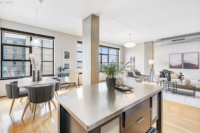 333 NW 9th Ave Unit 713, Portland, OR 97209 - kitchen with stainless steel countertops, light wood-style flooring, open floor plan, and hanging light fixtures