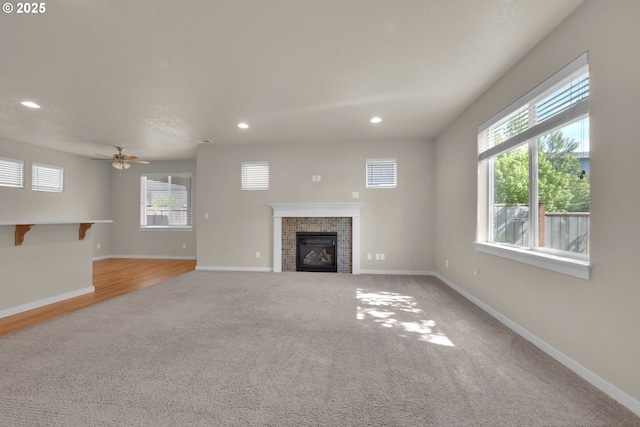 3015 Guadalupe Way, Eugene, OR 97408 - unfurnished living room featuring a tiled fireplace, light carpet, recessed lighting, baseboards, and a ceiling fan