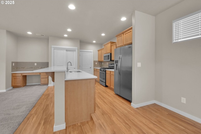 3015 Guadalupe Way, Eugene, OR 97408 - kitchen featuring stainless steel appliances, backsplash, light countertops, a kitchen island with sink, and recessed lighting