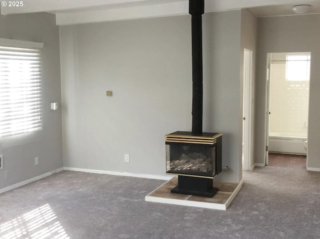 2544 NE Hoyt St, Portland, OR 97232 - unfurnished living room with a wood stove, carpet, plenty of natural light, and baseboards