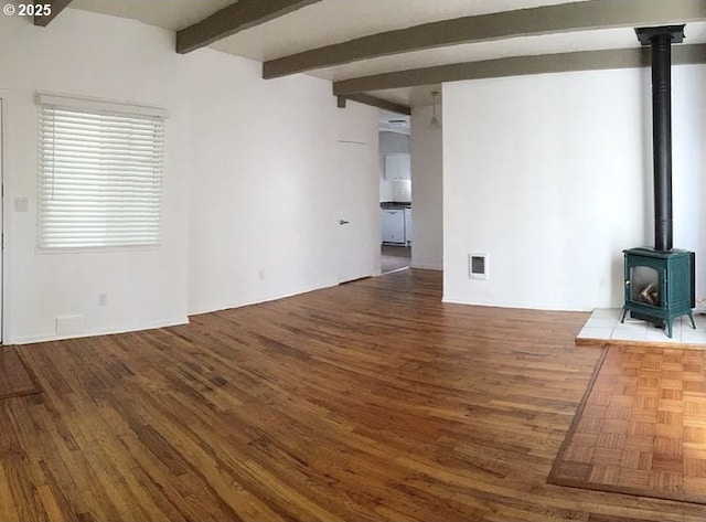 2544 NE Hoyt St, Portland, OR 97232 - unfurnished living room with a wood stove, parquet floors, visible vents, and beamed ceiling