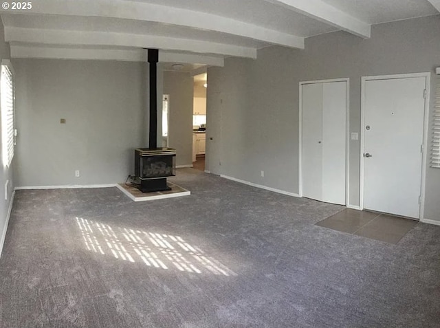 2544 NE Hoyt St, Portland, OR 97232 - unfurnished living room featuring beam ceiling, a wood stove, carpet, and baseboards