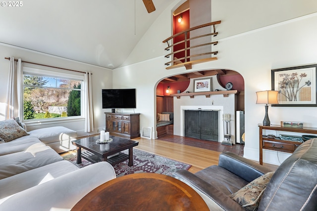 2783 NE Wiberg Ln, Portland, OR 97213 - living room with arched walkways, wood finished floors, ceiling fan, high vaulted ceiling, and baseboards