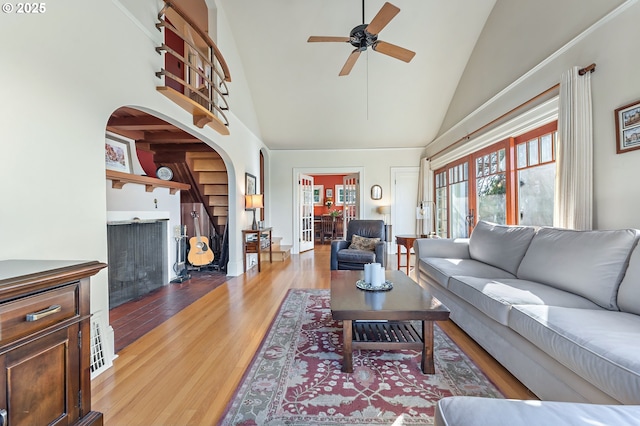 2783 NE Wiberg Ln, Portland, OR 97213 - living room with high vaulted ceiling, arched walkways, a ceiling fan, light wood-style flooring, and stairs