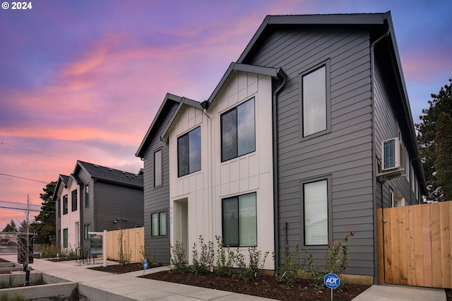 view of front of home with board and batten siding and fence