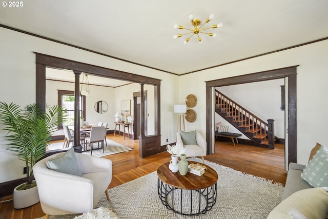 4919 NE 18th Ave, Portland, OR 97211 - living area featuring wood finished floors, stairway, ornate columns, crown molding, and a chandelier