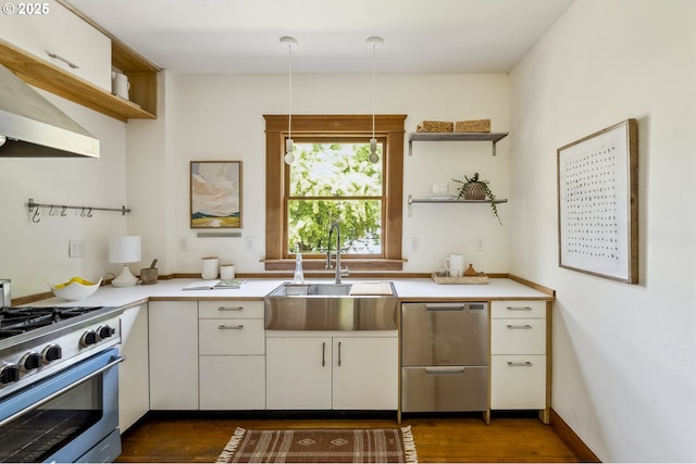4919 NE 18th Ave, Portland, OR 97211 - kitchen with open shelves, stainless steel appliances, wall chimney range hood, light countertops, and dark wood-style flooring