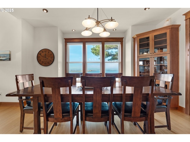 dining area featuring recessed lighting, baseboards, an inviting chandelier, and light wood-type flooring