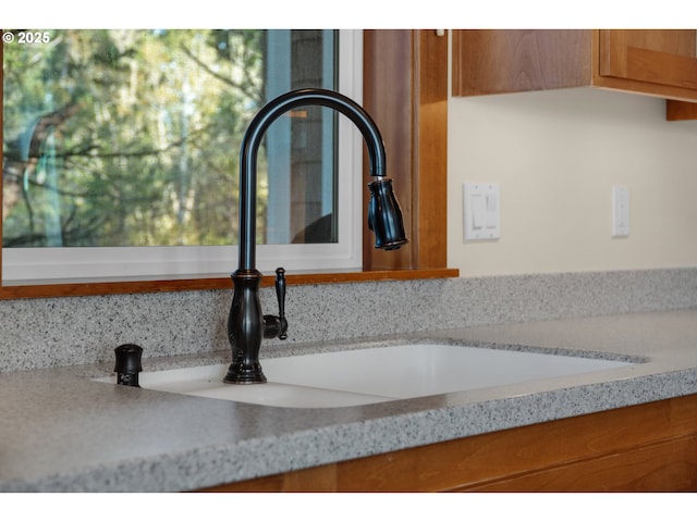 room details featuring brown cabinetry and a sink