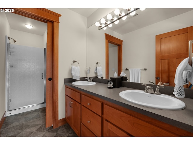 full bath featuring a sink, baseboards, a stall shower, and double vanity