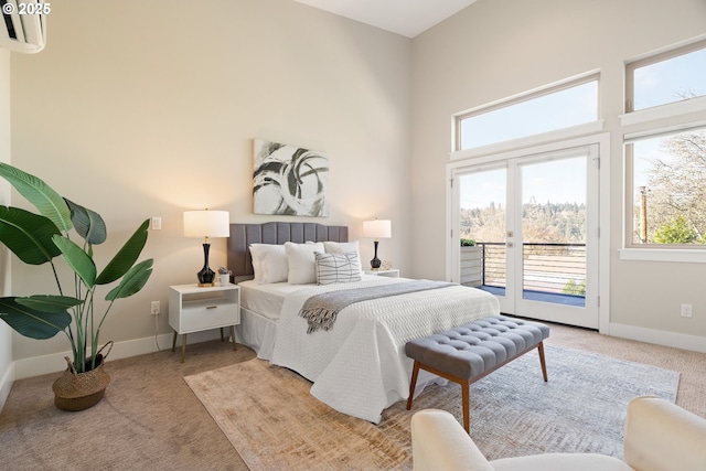 bedroom with access to exterior, baseboards, a high ceiling, and carpet