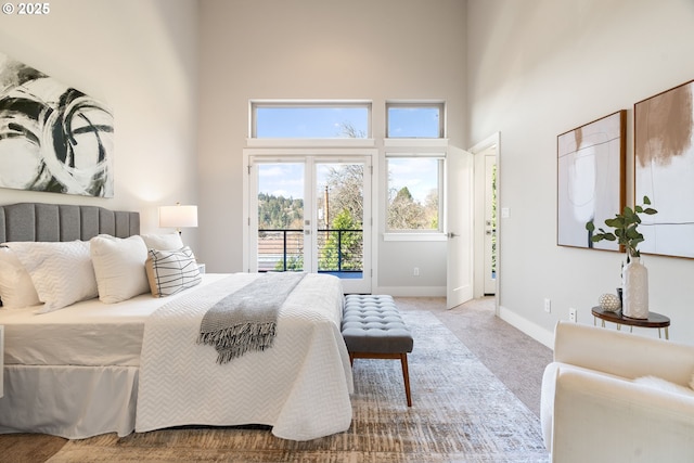 carpeted bedroom featuring french doors, baseboards, a high ceiling, and access to outside