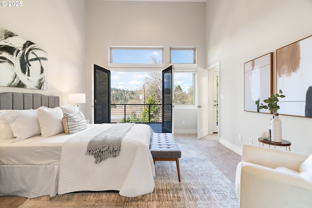 bedroom featuring baseboards, carpet floors, and a high ceiling