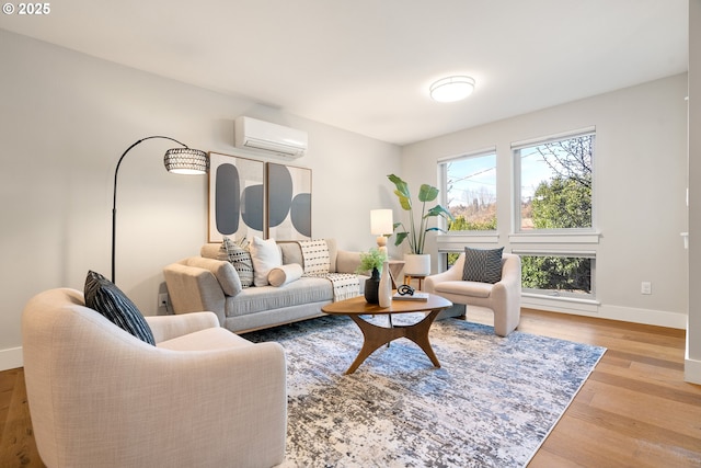 living room with a wall mounted AC, baseboards, and wood finished floors