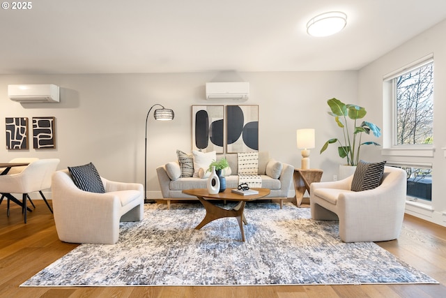 living area with wood finished floors and a wall mounted AC