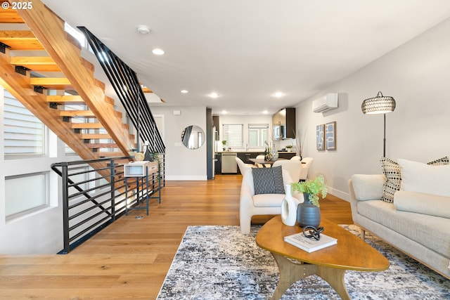 living area with stairway, light wood-style flooring, recessed lighting, and baseboards