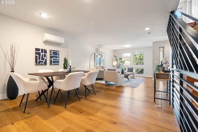 dining space featuring recessed lighting, an AC wall unit, light wood-style flooring, and stairs