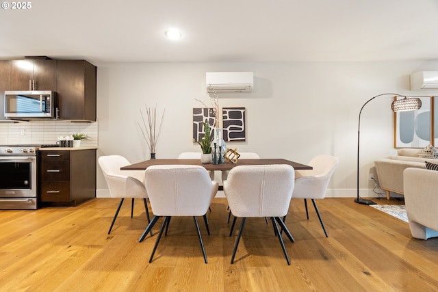 dining space featuring recessed lighting, baseboards, light wood-style flooring, and a wall unit AC