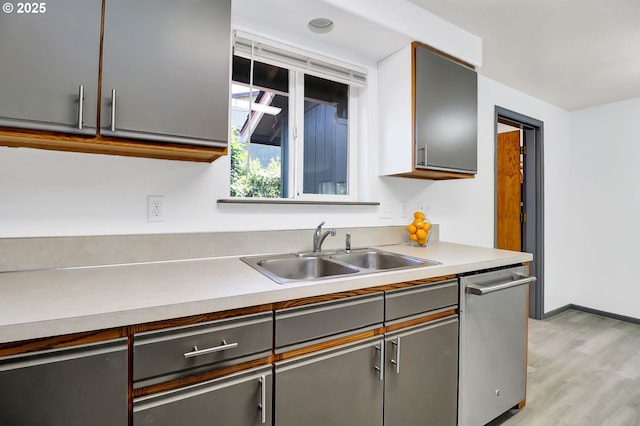 70 Jefferson Aly, Eugene, OR 97402 - kitchen with stainless steel dishwasher, a sink, light wood-style flooring, gray cabinetry, and light countertops