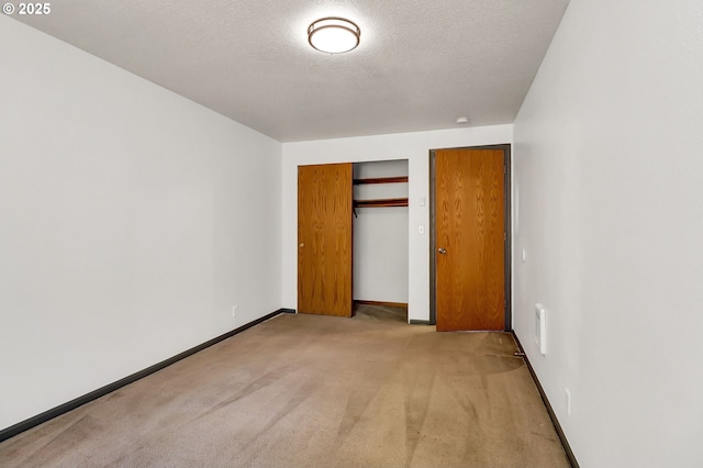 70 Jefferson Aly, Eugene, OR 97402 - unfurnished bedroom featuring light carpet, baseboards, a closet, and a textured ceiling