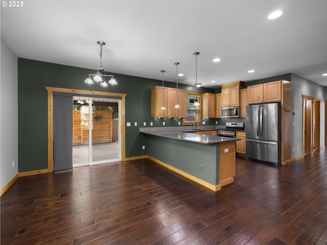 kitchen featuring stainless steel appliances, a peninsula, a chandelier, recessed lighting, and baseboards