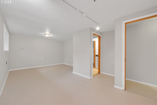 basement with a textured ceiling and light colored carpet