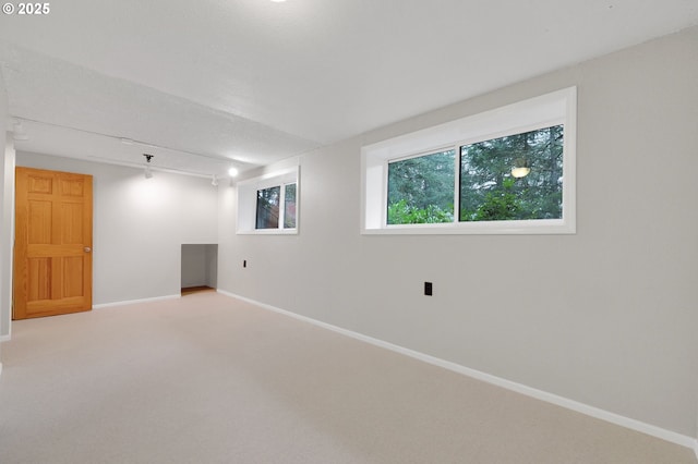 carpeted spare room featuring track lighting