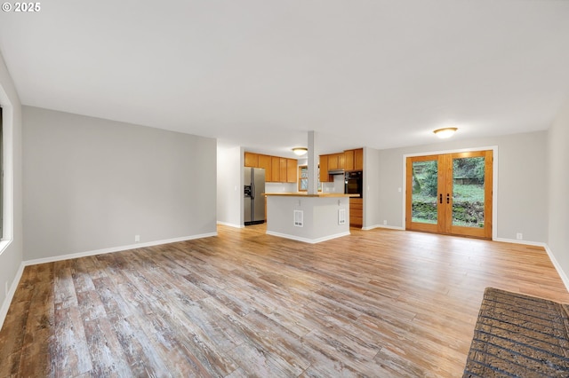 unfurnished living room featuring light hardwood / wood-style flooring and french doors