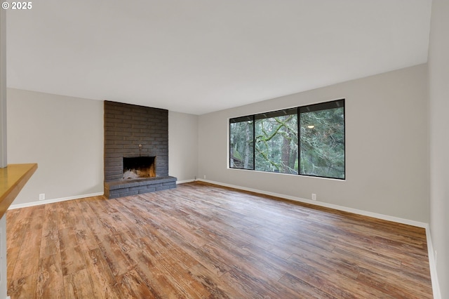 unfurnished living room featuring a fireplace and wood-type flooring