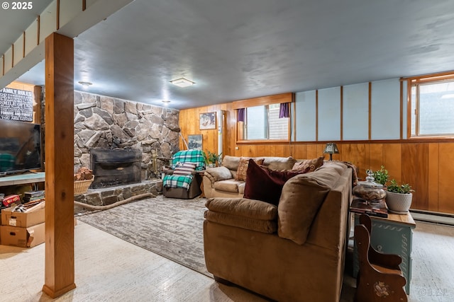 living area featuring wood walls, a fireplace, and a healthy amount of sunlight