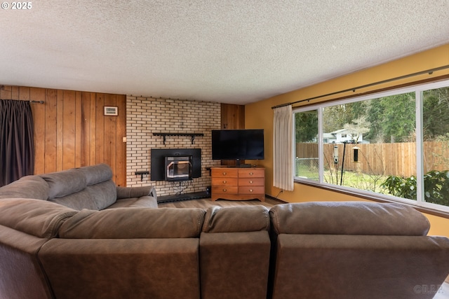 living area featuring wooden walls and a textured ceiling