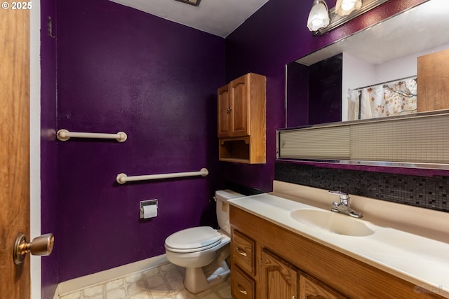 bathroom featuring baseboards, vanity, toilet, and tile patterned floors