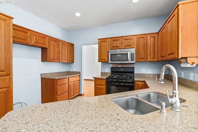 4060 Hampshire Ln, Eugene, OR 97404 - kitchen with stainless steel microwave, gas range oven, light stone counters, brown cabinets, and recessed lighting