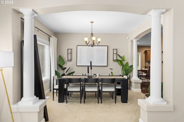 15655 SW Greenfield Dr, Portland, OR 97224 - dining area featuring light colored carpet, ornate columns, arched walkways, and a chandelier