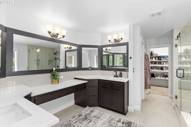 15655 SW Greenfield Dr, Portland, OR 97224 - bathroom featuring a chandelier, a stall shower, two vanities, a walk in closet, and tile patterned flooring