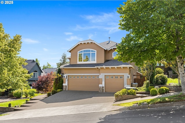 15655 SW Greenfield Dr, Portland, OR 97224 - view of front facade with stucco siding, concrete driveway, an attached garage, and stone siding